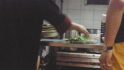 7月23日，漢麗軒烤肉超市昌平店，服務(wù)員將幾盤顧客剩菜（左手中疊在一起的是幾盤肉，其右手正整理韭菜）端回后廚，進(jìn)行整理后準(zhǔn)備再送往餐廳自助取餐區(qū)供顧客食用。